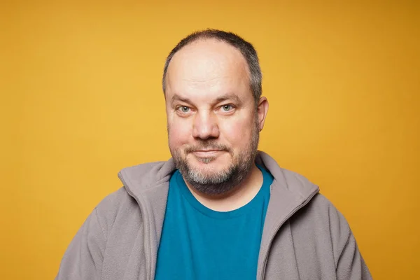 Casual chubby mature man against yellow background — ストック写真