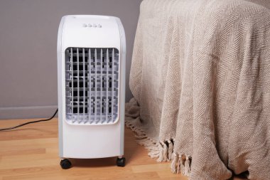 portable air cooler and humidifier on casters in domestic living room to improve indoor clmate clipart