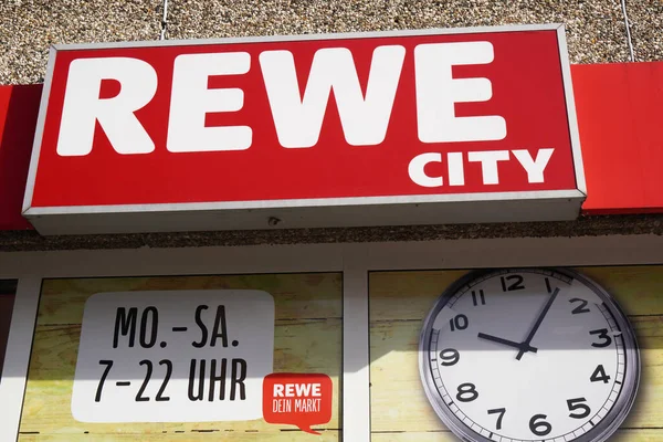 Rewe City logotipo sinal e tempos de abertura da cadeia de supermercados alemão — Fotografia de Stock