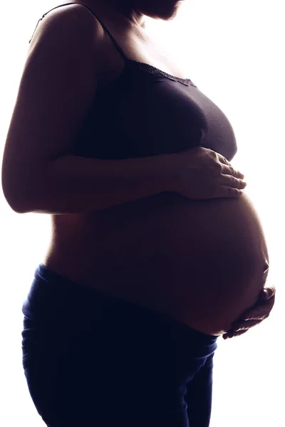 シルエットの肖像画妊娠中の女性の白い背景 両手で腹を保持 — ストック写真