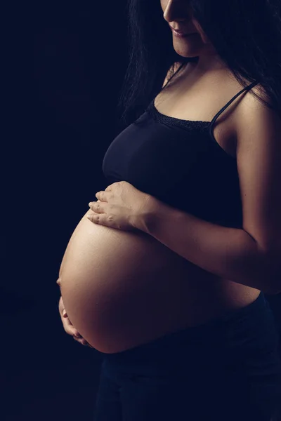 小さな光を明らかに妊娠中の女性 両手で腹を保持 — ストック写真