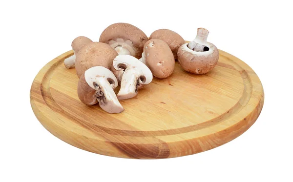 Kastanje champignons, geheel en gehalveerd op een houten bord — Stockfoto