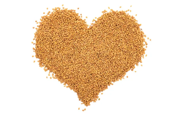 Dried fenugreek seeds in a heart shape — Stock Photo, Image