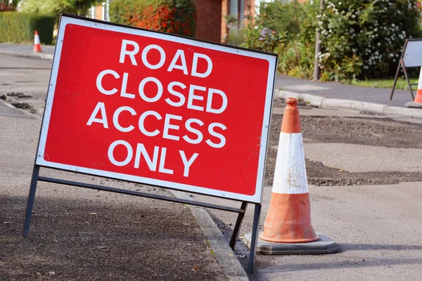 ROAD CLOSED ACCESS ONLY road sign with a traffic cone — Stock Photo, Image
