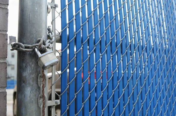 Candado y cadena de servicio pesado en la puerta de seguridad azul — Foto de Stock