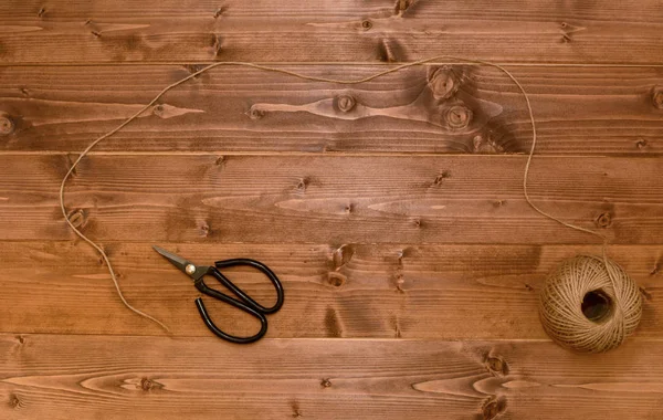 Boule de ficelle déroulée sur un fond en bois — Photo