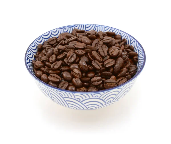 Жареные кофейные зерна в сине-белой миске — стоковое фото