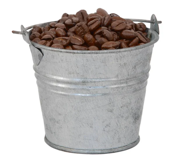 Темные жареные кофейные зерна в металлическом ведре — стоковое фото