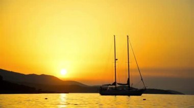 Yelken gemi su ufukta ile tropikal günbatımı arka plan
