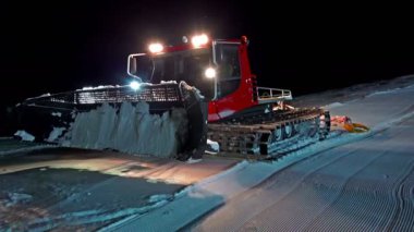 4 k kırmızı snowcat ratrac traktör bir kayak merkezinde skislope geceleri hazırlar. Uhg steadycam stok video