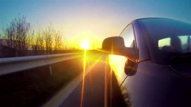 Zaman atlamalı bir gün batımı ışınları de kırsal yol sürüş araba