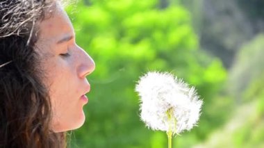 Ağır çekim kadın karahindiba üzerinde üfleme