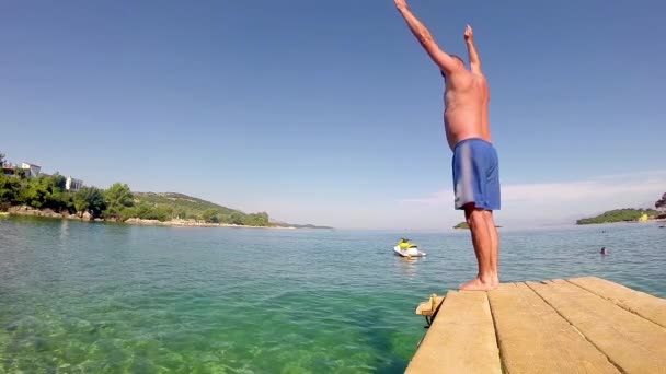 Zeitlupe Eines Männlichen Berufsschwimmers Der Von Der Seebrücke Springt — Stockvideo