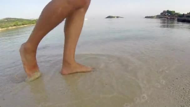 濡れた砂の島ビーチで裸足で歩く男性の足 — ストック動画