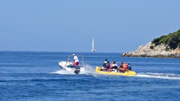 Boot Zieht Eine Wasserbanane Mit Menschen Darauf — Stockvideo