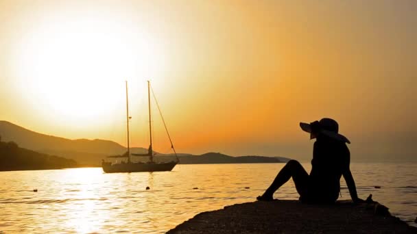 Vrouwelijke Silhouet Met Stro Hoed Kijken Naar Zonsondergang Boot Zee — Stockvideo