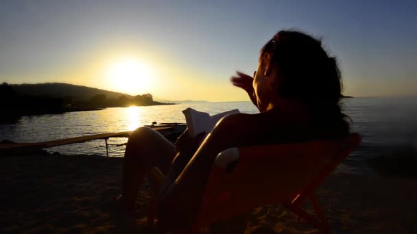 Vrouw Lezen Boek Zonsondergang Achtergrond — Stockvideo