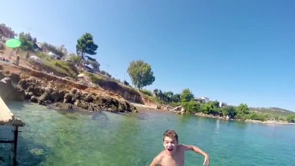 Fiatal férfiak jumping, úszhat a tengerben, lassú mozgás ugrás lövés víz alatti, stock videóinak egyértelmű vizeken