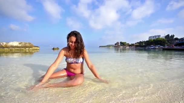 Улыбающаяся Девушка Сидящая Веселящаяся Летнем Пляже — стоковое видео