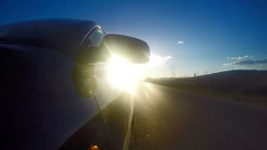 Zaman atlamalı bir gün batımı ışınları de kırsal yol sürüş araba