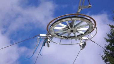 Tekerlek ve teleferik yeşil ağaç yakınındaki bulutlu mavi gökyüzü karşı kablo yakın çekim