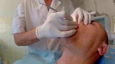 Dişçi işyerinde yetişkin erkek hastanın diş implant için hazırlanıyor