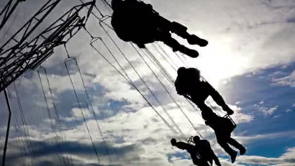 Mensen Silhouetten Rijden Keten Swing Bewolkte Hemelachtergrond — Stockvideo