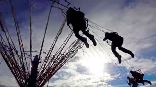 Mensen Silhouetten Rijden Keten Swing Bewolkte Hemelachtergrond — Stockvideo