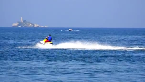 Man Rijden Oceaan Jetski Met Zeilboot Achtergrond — Stockvideo