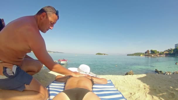 Hombre Aplicando Loción Bloqueadora Solar Espalda Mujer Quad — Vídeos de Stock