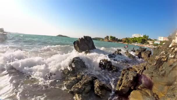 夕日を背景に海の岩に砕ける波のスローモーション — ストック動画