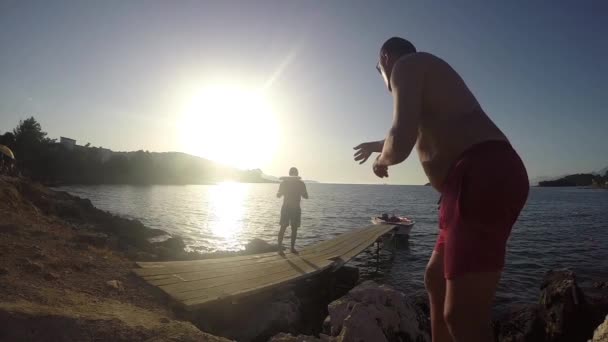 Twee Jongens Samenspelen Frisbee Korte Broek Bij Zonsondergang Oceaan Pier — Stockvideo