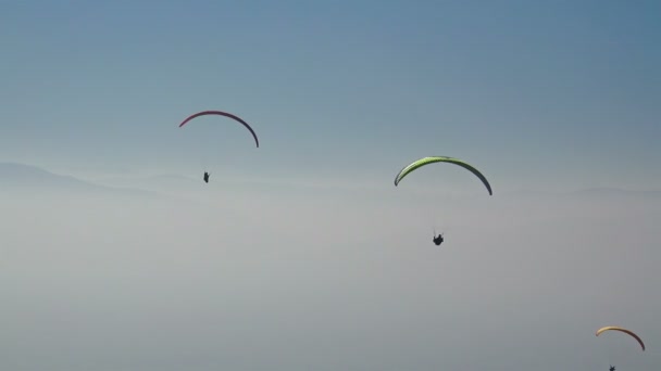 Vue Aérienne Parapentes Glissant Dessus Une Chaîne Montagnes Couvertes Brouillard — Video