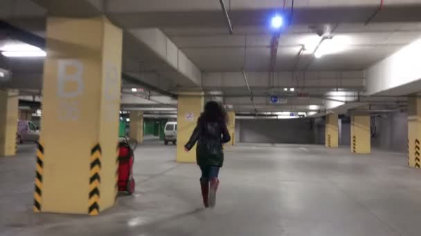 时尚女孩在地下商场停车场的电话里散步和交谈 — 图库视频影像