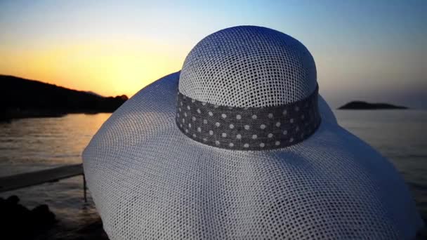 女孩在海滩上的帽子在日落期间 — 图库视频影像