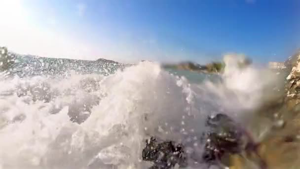 夕日を背景に海の岩に砕ける波のスローモーション — ストック動画