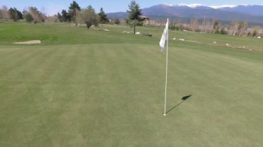 Bakış açısı ile doğa zemin üzerine yeşil çimenlerin üzerinde golf bayrak