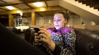 Divan otel oturan smartphone kullanan kız