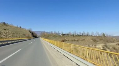 Sarı çitlerle çevrili köprü boyunca kırsal yolda sürüş