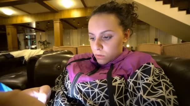 Ragazza Utilizzando Smartphone Seduto Sul Divano Hotel — Video Stock