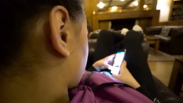 女孩使用智能手机坐在沙发上的酒店 — 图库视频影像