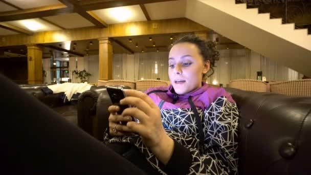 Girl Using Smartphone Sitting Sofa Hotel — Stock Video