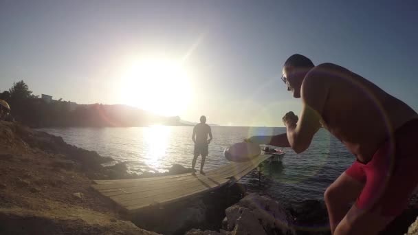 Двое Мужчин Играют Фрисби Тропическом Пляже Против Заката Солнца Горой — стоковое видео