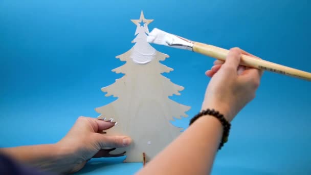Vrouw handen schilderij kleine houten kerstboom — Stockvideo