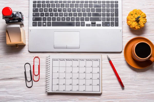 Computador e calendário escrito à mão em mesa de madeira — Fotografia de Stock