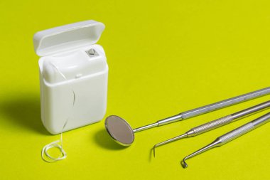 Diş ipi ve aletleri yeşil arka plan üzerinde