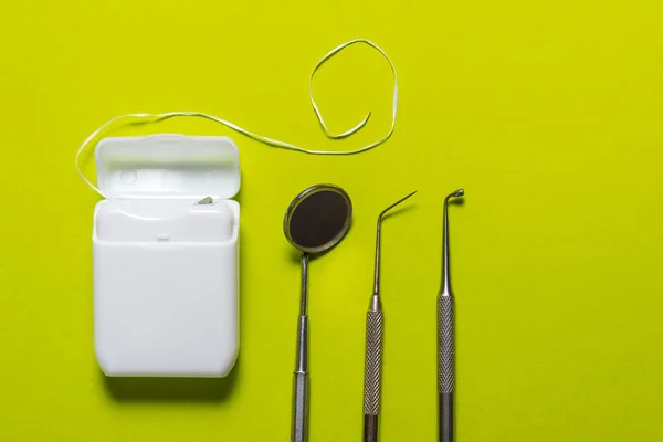 Зубная нить и инструменты на зеленом фоне — стоковое фото