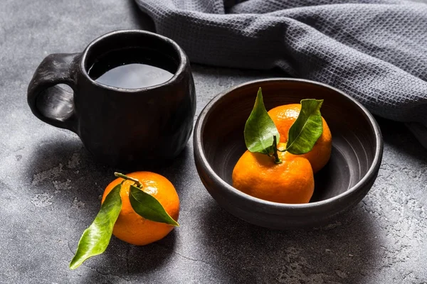 Šálek čaje černé keramické stolní nádobí a mísy na šedý stůl — Stock fotografie