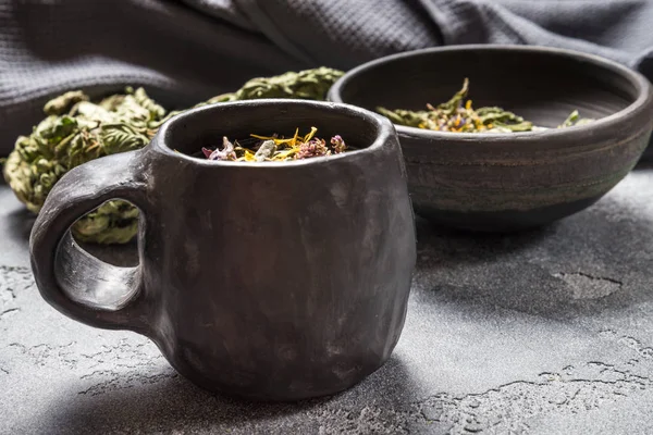 Трав'яний чай в чорному керамічному столовому посуді — стокове фото