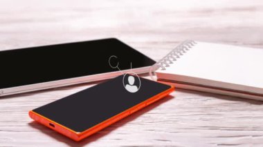 Cep telefonu, tablet ve defter ofis ahşap masasında, animasyonlu sosyal ağ